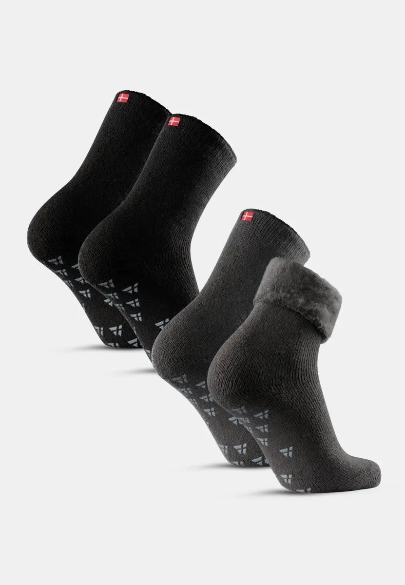 Three pairs of dark non-slip socks with grip soles; one pair features a fluffy cuff.