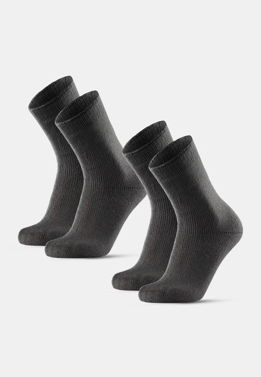 Four dark gray non-slip heat socks standing upright, highlighting ribbed texture and ankle length.