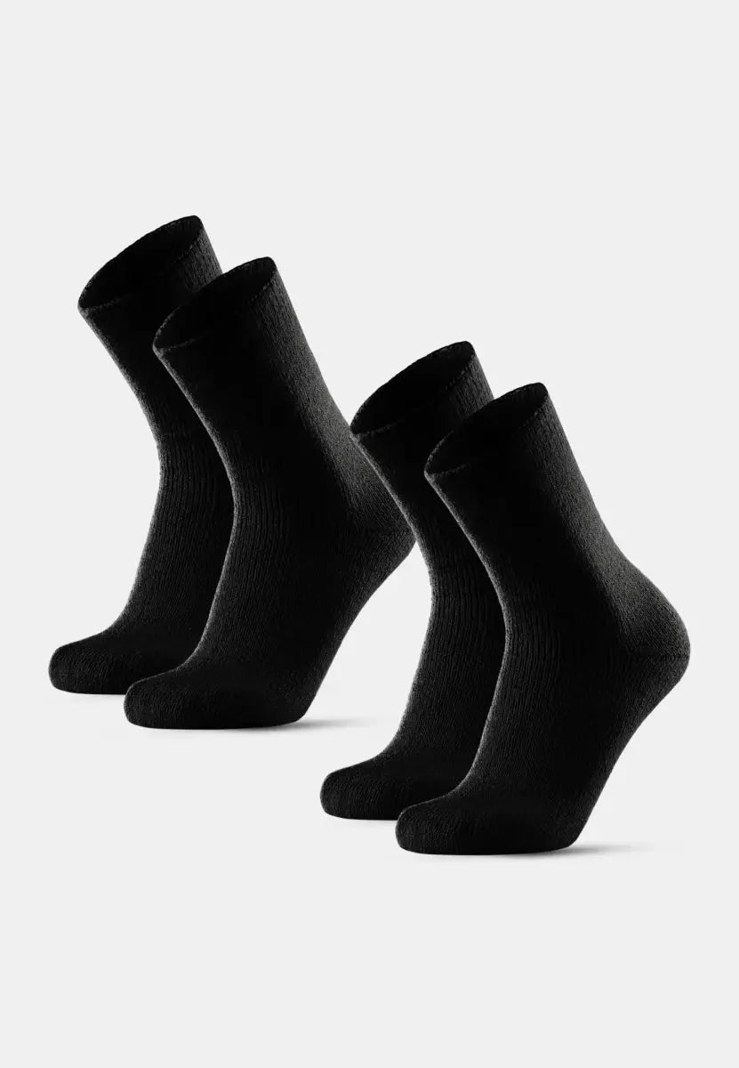 Four black, textured non-slip socks standing upright on a plain white background.