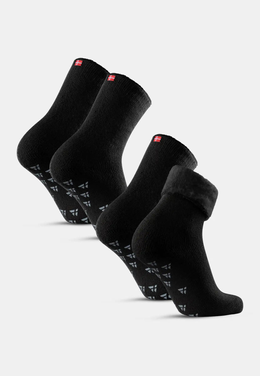Three pairs of black non-slip socks with flag detail and grip design on the soles.