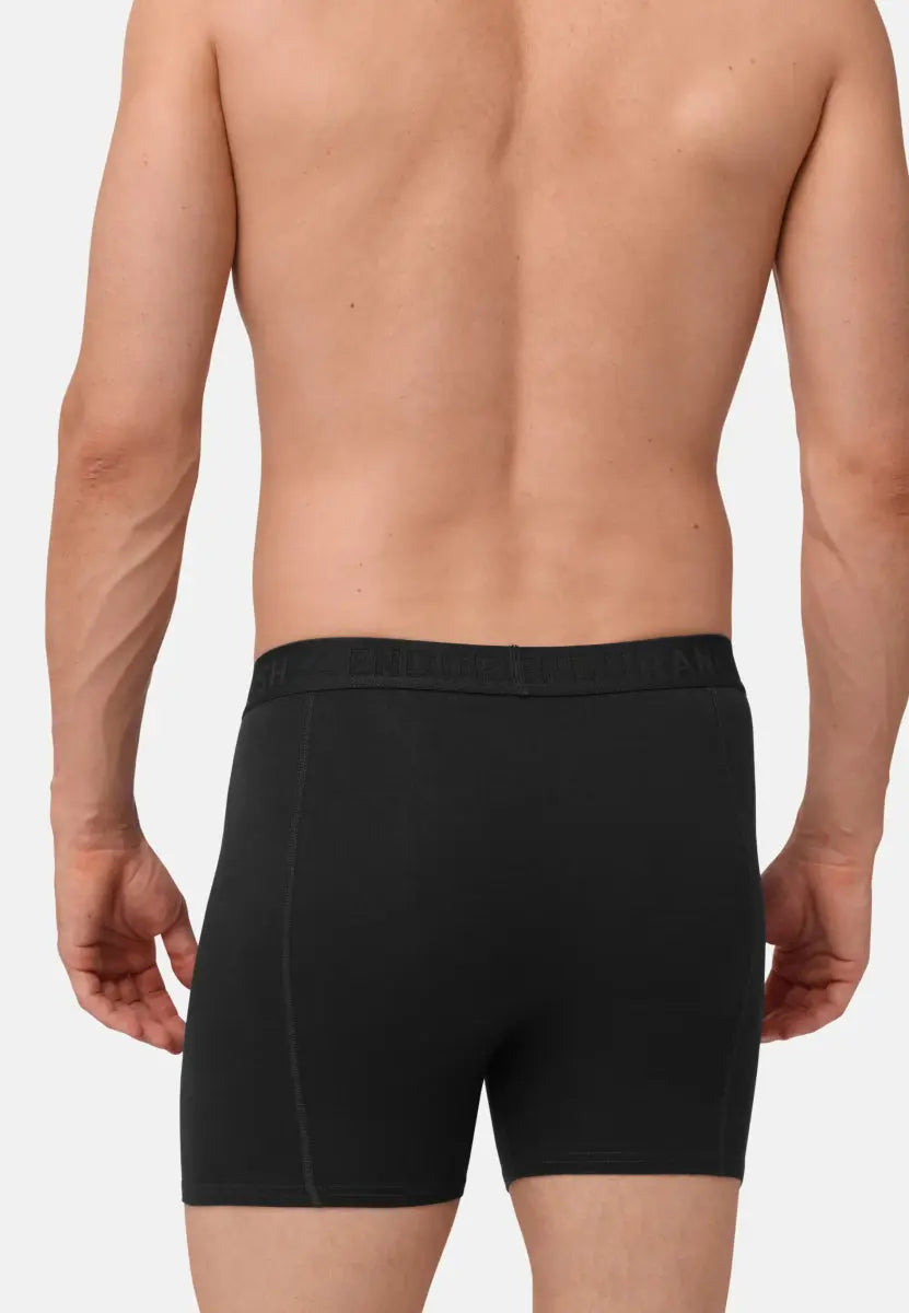 Man wearing black organic cotton trunks, viewed from the back, showcasing fit and waistband detail.