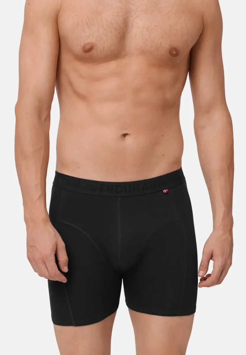 Black organic cotton trunks worn by a person, showing fit and waistband details, with a plain background.