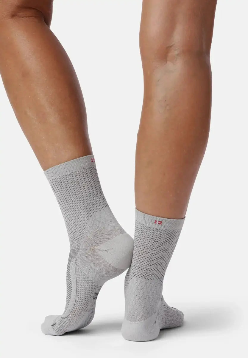 Gray plantar fasciitis socks on legs, showcasing textured design for foot support.