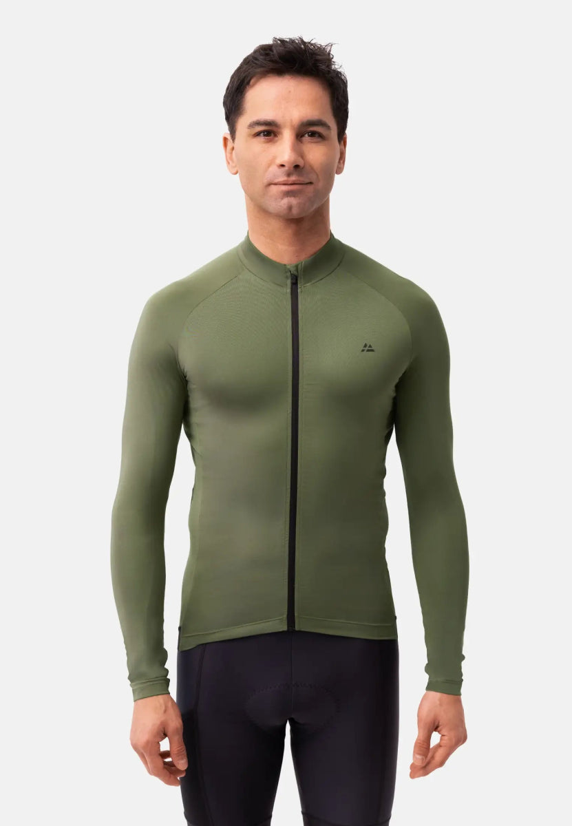 Man wearing olive green long-sleeve cycling jersey with front zipper, plain background.