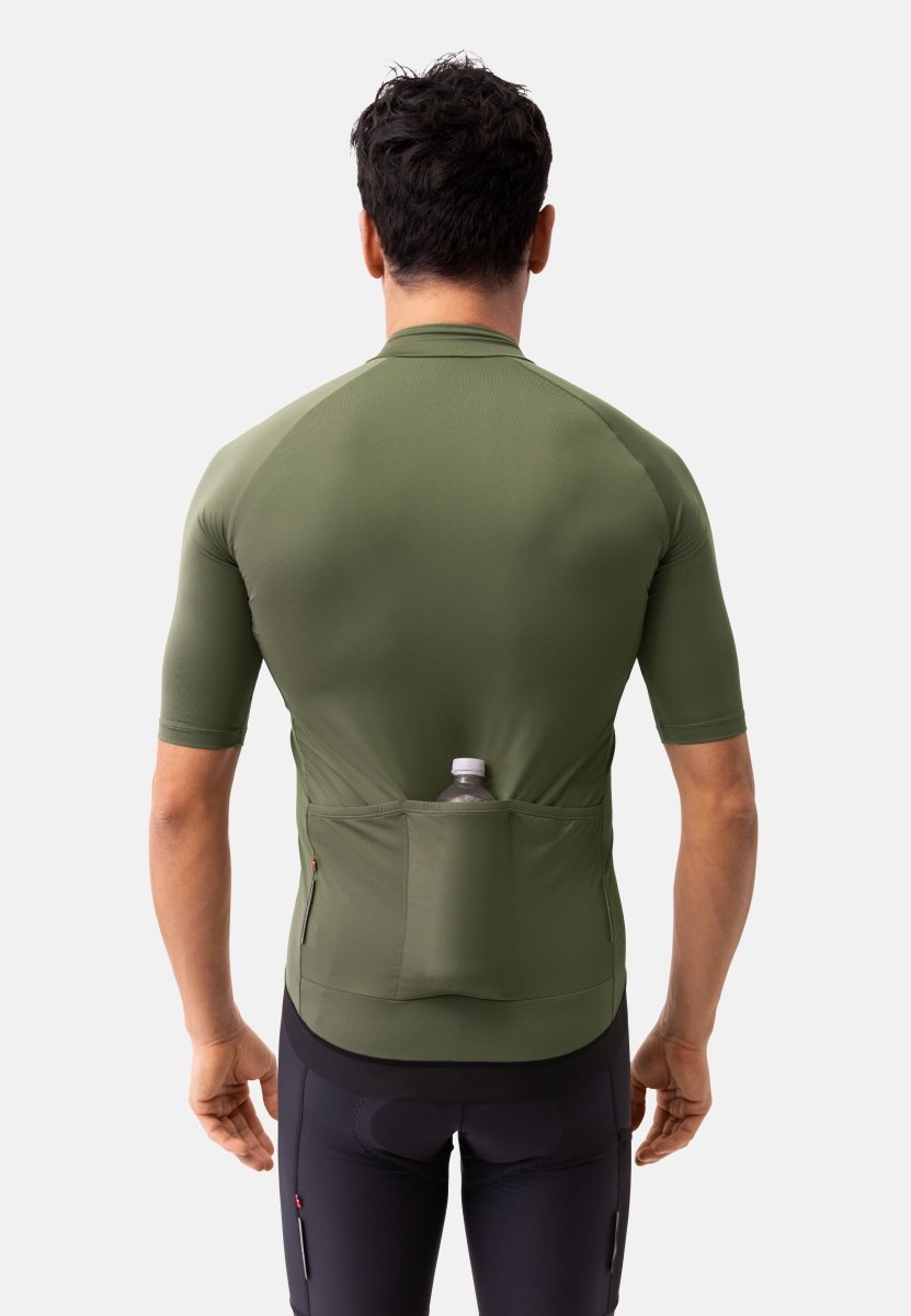 Back view of a man in a green cycling jersey with a water bottle in the rear pocket.
