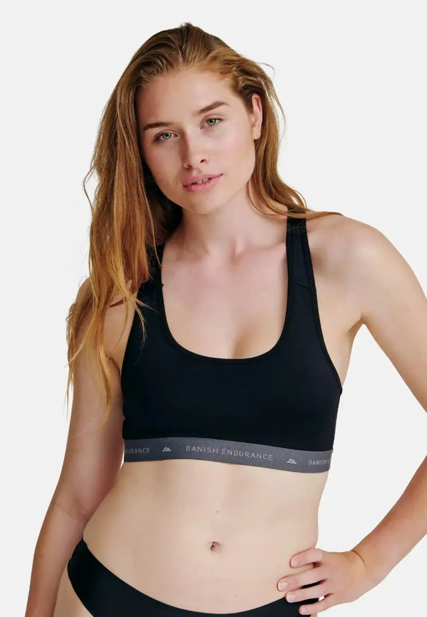 Person in black racerback sports bra with "Danish Endurance" logo on the band.