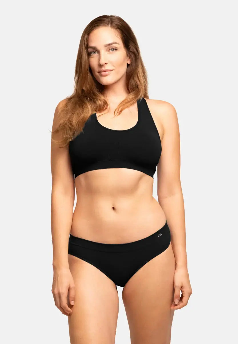 Person wearing a black seamless bamboo bikini with a racerback top and matching bottoms.