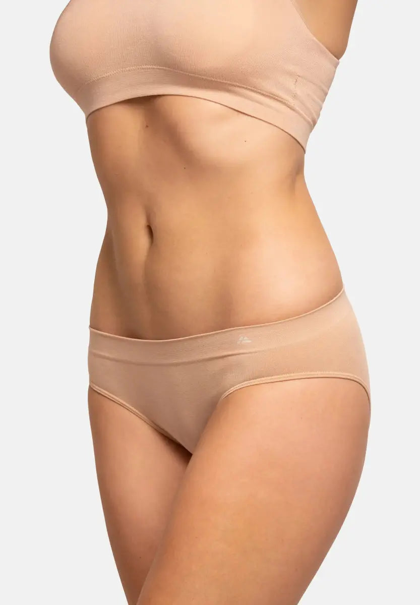 Person wearing a seamless bamboo bikini in neutral color, highlighting waist and hip area.