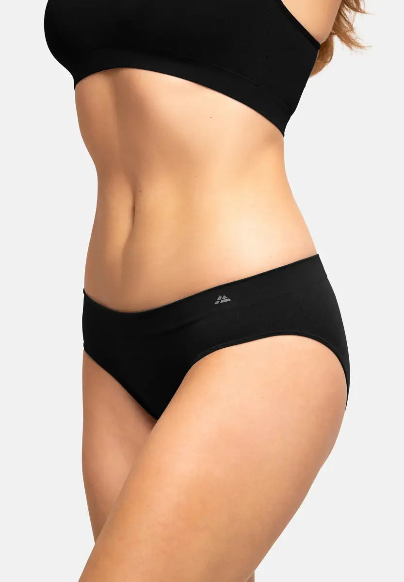 Woman wearing a black seamless bamboo bikini, showing waist and hips, with a plain background.