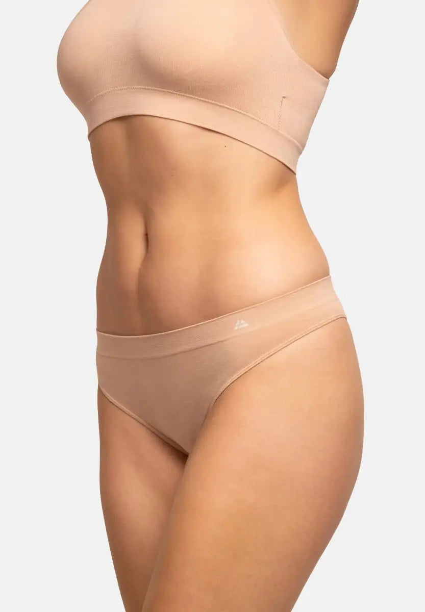 Torso wearing a beige seamless bamboo thong, showcasing its smooth texture and snug fit.