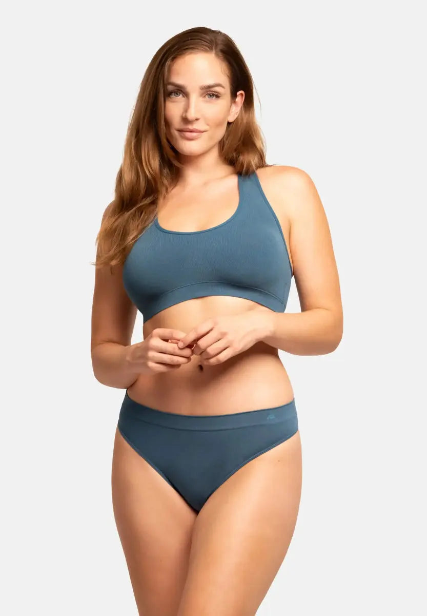 Woman in blue seamless bamboo thong and matching sports bra, front view.