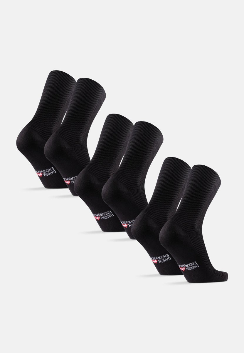 Six pairs of black crew socks with brand logo on soles, arranged in a row.