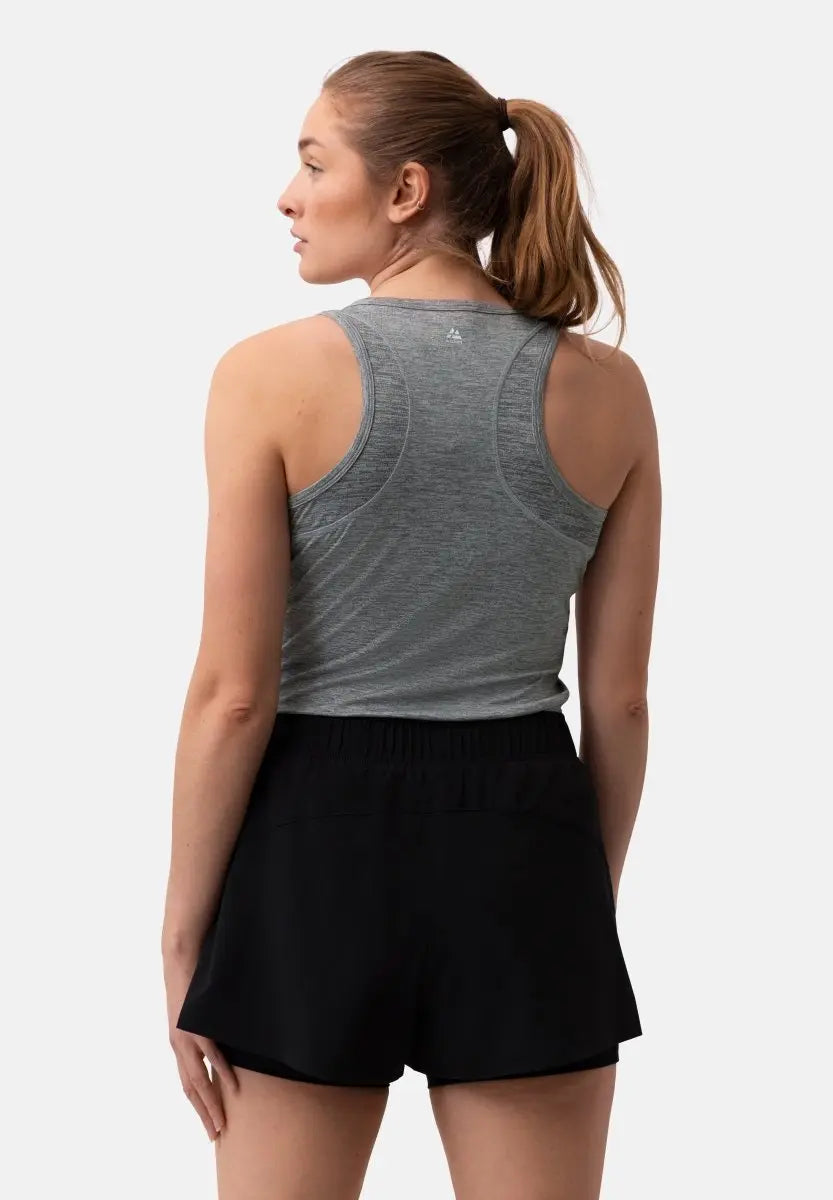Woman in gray tank top and black shorts, viewed from the back, hair in a ponytail.