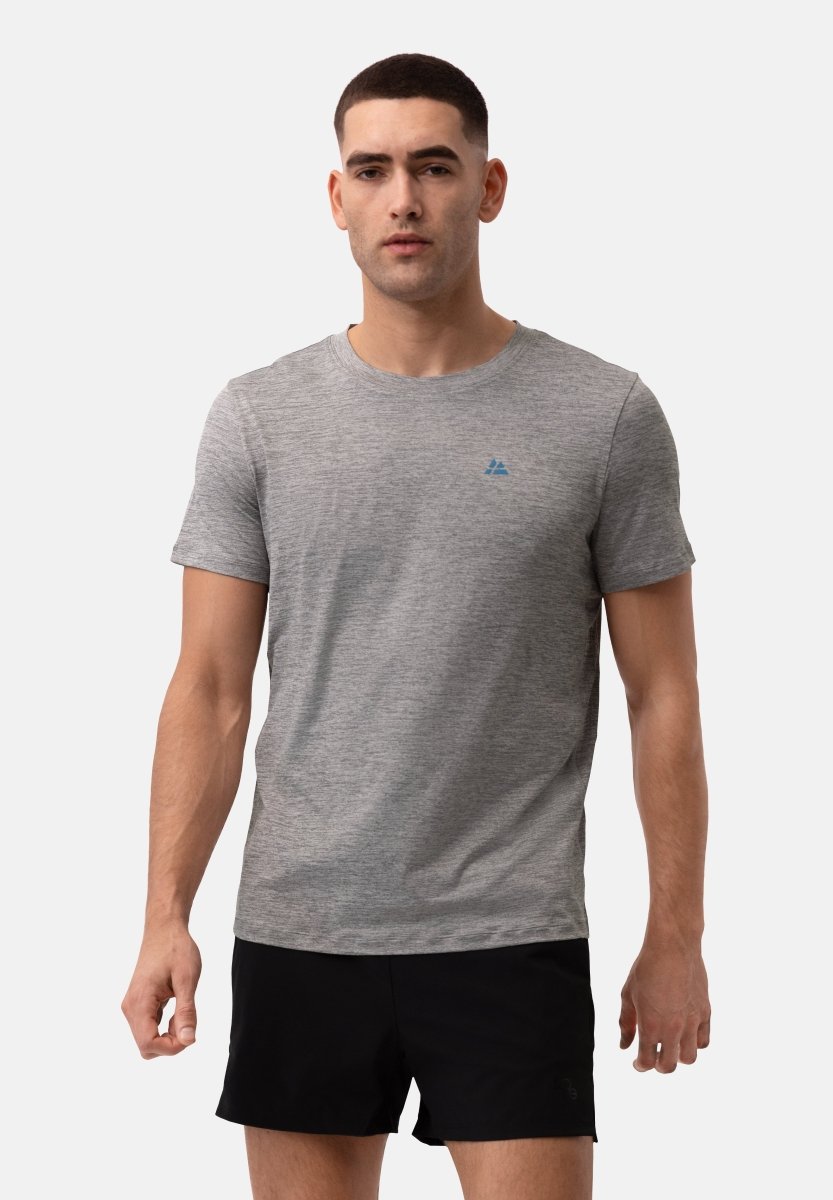 Man in grey performance T-shirt with blue logo on chest, paired with black shorts.