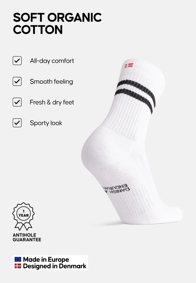 White sock with black stripes, labeled benefits: comfort, smooth, dry feet, sporty; Danish design.
