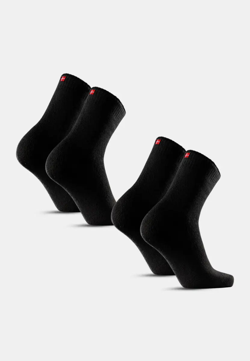 Two pairs of black thermal socks with red and white flag emblems on a plain background.