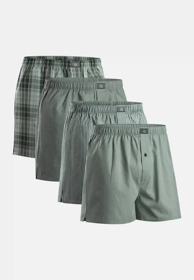 Four woven boxer shorts in plaid, solid, and striped patterns, arranged in a cascading display.