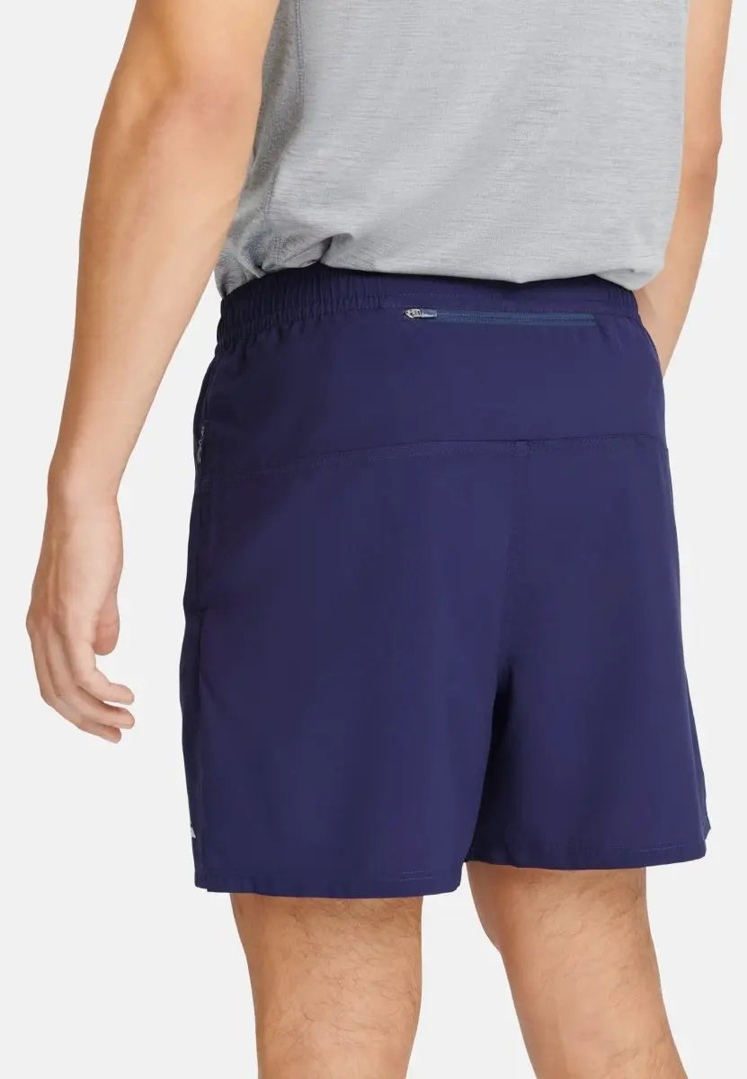 Navy blue sports shorts with back zipper pocket, worn by a person in a gray shirt.