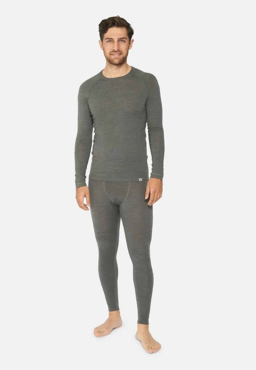 Man wearing gray merino wool base layer pants and top, standing barefoot on a plain background.