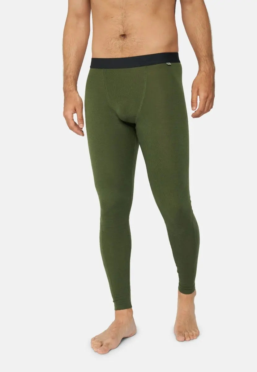 Man wearing olive green Merino wool base layer pants with black waistband, standing barefoot.