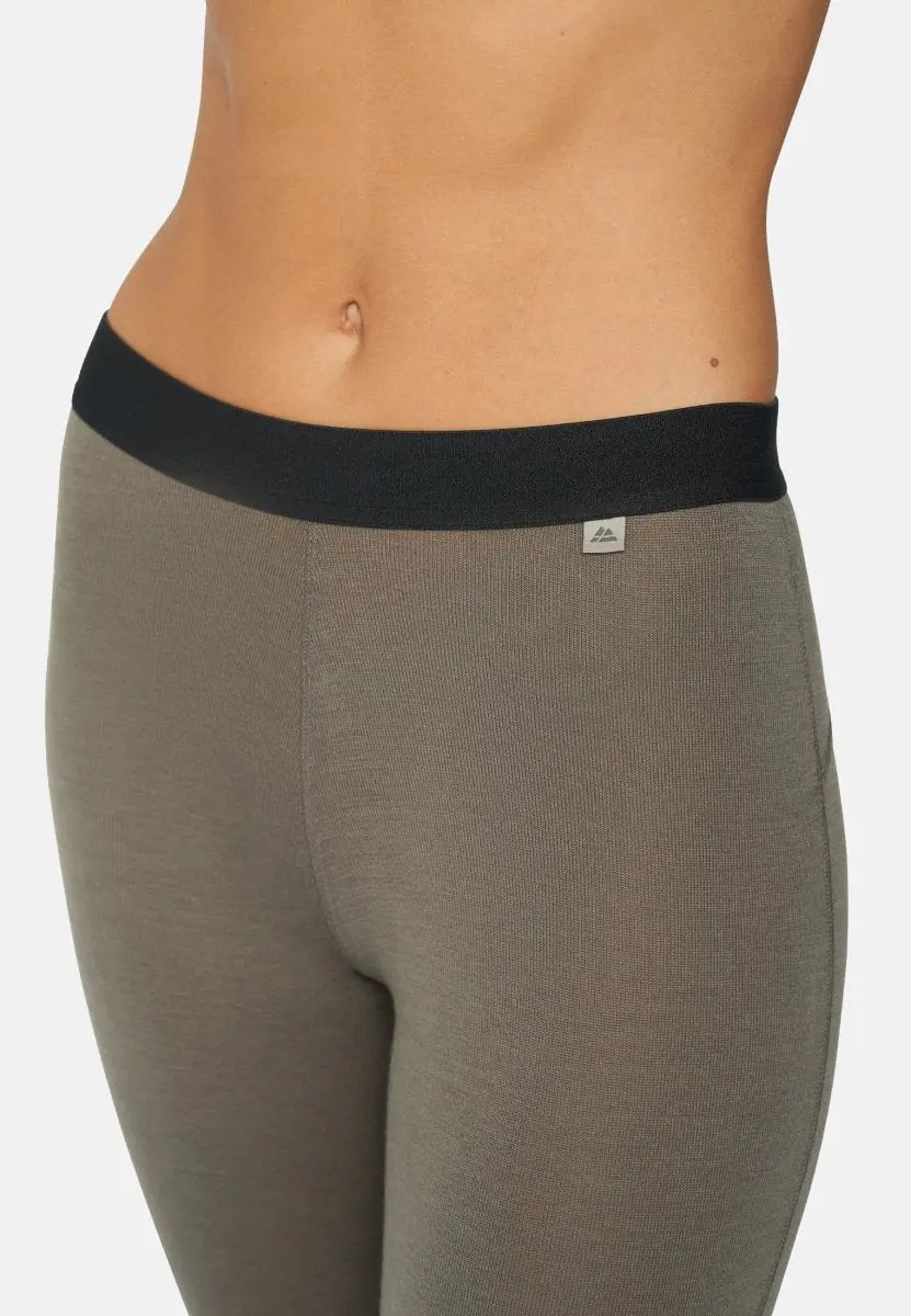 Close-up of gray merino wool pants with black waistband, showing midsection of the wearer.
