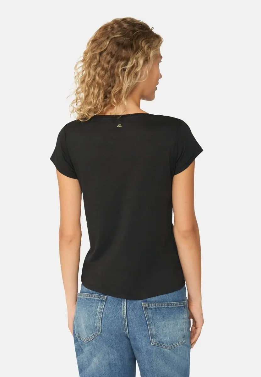 Woman from the back wearing a black V-neck T-shirt and blue jeans.