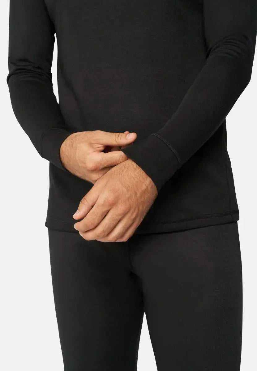 Person wearing black thermal underwear set, showing midsection and hands adjusting the sleeve.