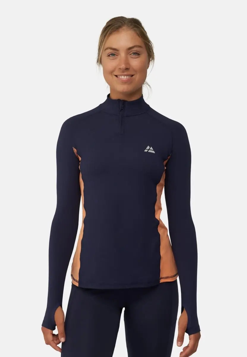 Woman in navy long-sleeve athletic shirt with peach side panels, smiling.