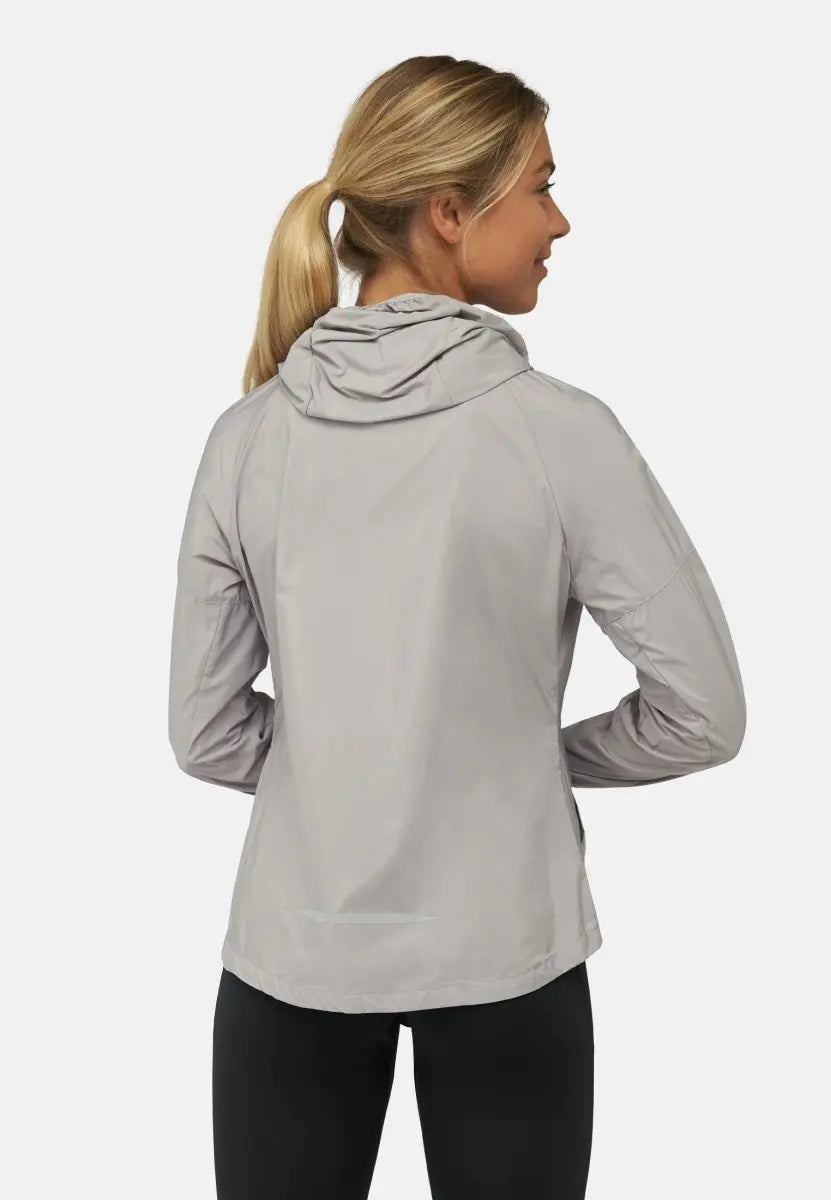 Woman in light gray hooded windbreaker, viewed from the back, against a plain background.