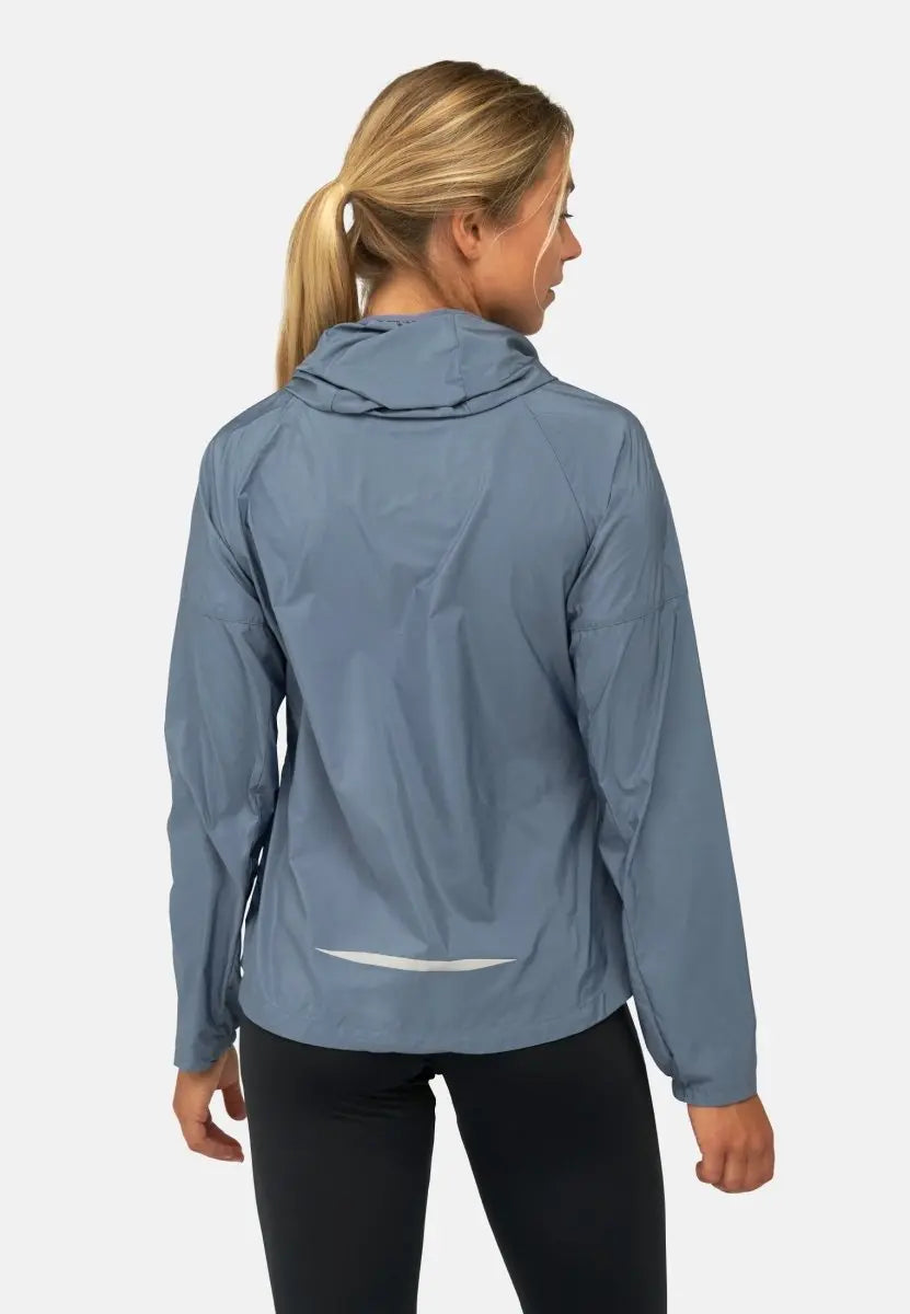 Woman in light blue hooded windbreaker jacket, viewed from the back, against a plain background.