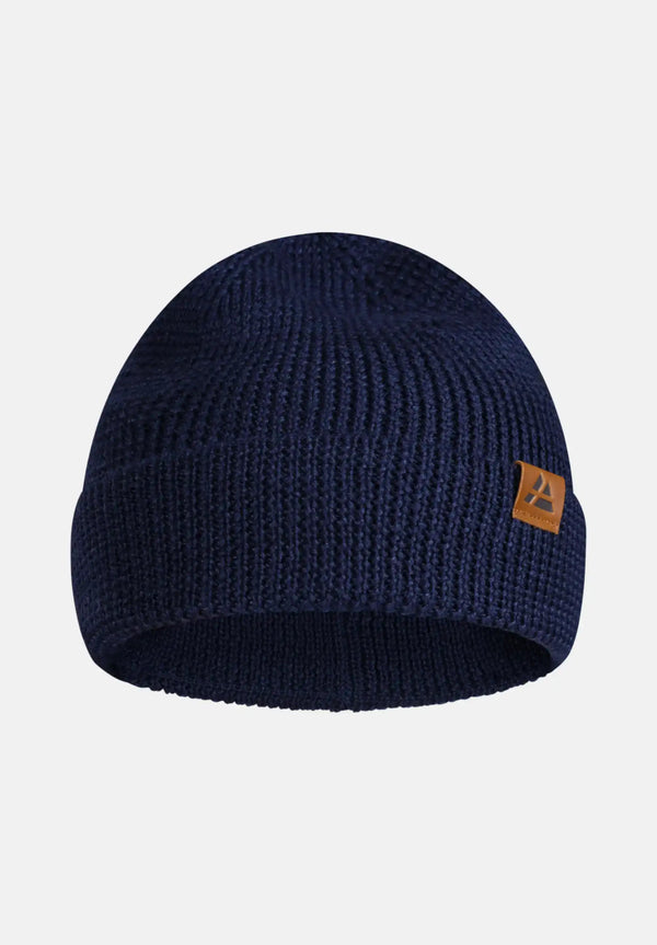 Navy blue knitted beanie with folded brim and brown leather logo patch on the side.